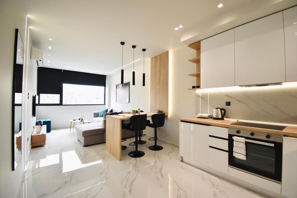 Modern open-plan living and kitchen area with marble floors, pendant lights, and white cabinetry.